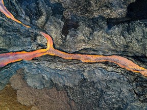 In this handout photo from the U.S. Geological Survey taken on Dec. 4 and obtained on Dec. 6, 2022, an aerial view shows the fissure 3 lava channel erupting from Mauna Loa's Northeast Rift Zone at the Mauna Loa Volcano near Hilo, Hawaii.