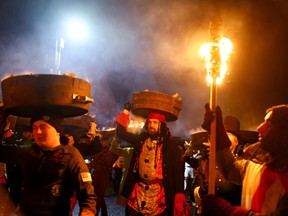 ‘Tar Barrel Men’ proceed through the streets of Allendale carrying torches and flaming barrels in the annual Allendale Tar Barrel festival, in Allendale, northern England, Britain, December 31, 2022. (REUTERS/Lee Smith)