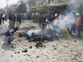 Police officers collect evidences at the site of a suicide car bombing in Islamabad, Pakistan, Dec. 23, 2022.