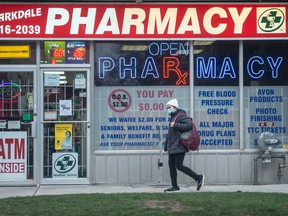A pedestrian walks past a pharmacy in Toronto's Parkdale neighbourhood on Monday, Nov. 28, 2022.