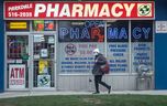 A pedestrian walks past a pharmacy in Toronto's Parkdale neighbourhood on Monday, Nov. 28, 2022.  