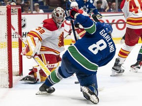 Vancouver Canucks Conor Garland (right) puts a shot on Calgary Flames goalie Dustin Wolf during NHL pre-season action in Vancouver, BC, September, 25, 2022.