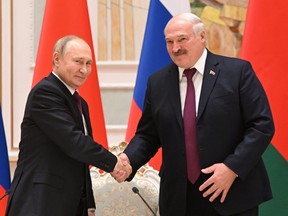 Russian President Vladimir Putin shakes hands with Belarusian President Alexander Lukashenko during a news conference following their meeting in Minsk, Belarus, Dec. 19, 2022.