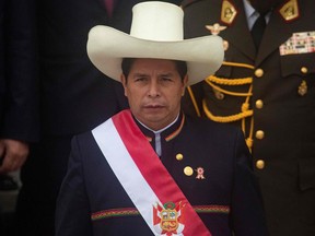 In this file photo taken on July 28, 2021 Peruvian President Pedro Castillo wears the presidential sash as he exits the Congress after his inauguration ceremony in Lima.