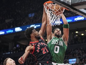 Boston Celtics forward Jayson Tatum (0) dunks against Toronto Raptors forward Thaddeus Young (21) during the first half at Scotiabank Arena.