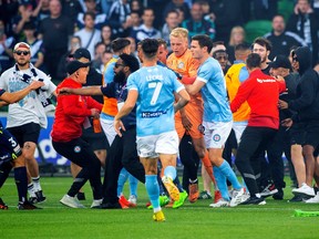 Melbourne City's Thomas Glover reacts as fans invade the pitch during the Melbourne City v Melbourne Victory match at AAMI Park, Melbourne, Australia on December 17, 2022.