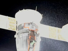 A stream of particles, which NASA says appears to be liquid and possibly coolant, sprays out of the Soyuz spacecraft on the International Space Station, forcing a delay of a routine planned spacewalk by two Russian cosmonauts Dec. 14, 2022 in this still image taken from video.