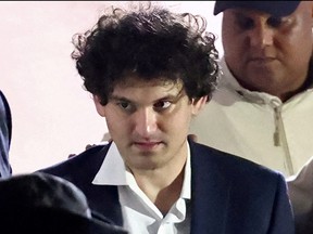 Sam Bankman-Fried, who founded and led FTX until a liquidity crunch forced the cryptocurrency exchange to declare bankruptcy, is escorted out of the Magistrate Court building after his arrest in Nassau, Bahamas, Dec. 13, 2022.