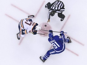 John Tavares of the Toronto Maple Leafs takes a faceoff against Connor McDavid of the Edmonton Oilers.