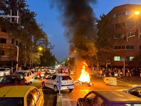 A police motorcycle burns during a protest over the death of Mahsa Amini, a woman who died after being arrested by the Islamic republic's "morality police", in Tehran, Iran, Sept. 19, 2022.