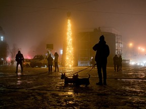 People walk past a Christmas tree during heavy fog at the Sofiyska square, amid Russia's invasion of Ukraine, in Kyiv, December 17, 2022.
