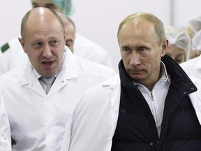 In this Monday, Sept. 20, 2010 file photo, businessman Yevgeny Prigozhin, left, shows Russian President Vladimir Putin, around his factory which produces school means, outside St. Petersburg, Russia.
