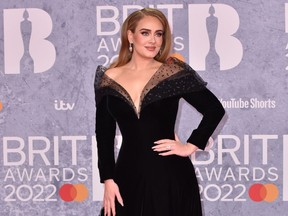 Adele poses on the red carpet at the BRIT Awards in February 2022.