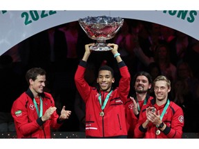 Canadas Felix Auger Aliassime (R) holds the trophy after Canada won the Davis Cup tennis tournament at the Martin Carpena sportshall, in Malaga on November 27, 2022.