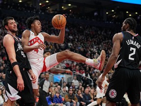 Raptors' Scottie Barnes comes down with a ball against L.A. Clippers' Ivica Zubac (40) and forward Kawhi Leonard during the first half at Scotiabank Arena on Tuesday, Dec. 27, 2022.
