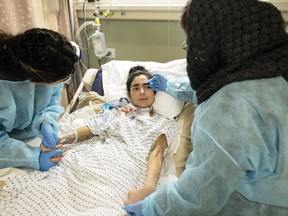 Negar Shaltouki, left, and their mother, Sedighe Mousavi, tend to Neggy Shelton, who is on life support at a health-care facility in Alexandria, Va., on Dec. 18. While Shelton's eyes sometimes open, she remains largely unresponsive with an extensive brain injury.
