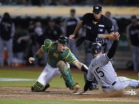 Oakland Athletics catcher Sean Murphy, left, tries to tag Chicago White Sox's Adam Engel, who scored the tying run during the ninth inning of a baseball game in Oakland, Calif., Sept. 9, 2022.