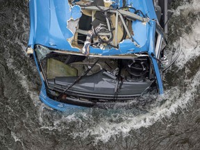 The wreck of a bus lies in the Lerez river in Cerdedo-Cotobade, northwestern Spain, Sunday, Dec. 25, 2022.