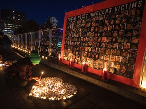 A mourner lights candles during a memorial for the anniversary of flight PS752 in Edmonton on Friday, Jan. 8, 2021. Canada is among four countries taking action intended to hold Iran legally accountable for shooting down Flight PS752 nearly three years ago.