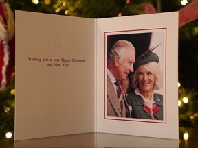 In this handout provided by Buckingham Palace on Dec. 11, 2022, the 2022 Christmas card of King Charles III and Camilla, Queen Consort, in front of a Christmas tree in Clarence House in London.