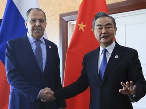 Russian Foreign Minister Sergey Lavrov, left, and Chinese Foreign Minister Wang Yi pose for a photo prior to their talks on the sideline of the 12th East Asia Summit foreign ministers' meeting in Phnom Penh, Cambodia, on Aug. 5, 2022.