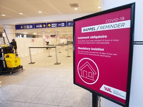 A sign reminds arriving passengers to self-quarantine against COVID-19 at Trudeau Airport in Montreal, February 19, 2021.