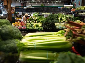 A woman shops for produce at the Granville Island Market in Vancouver, on Wednesday, July 20, 2022.