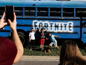 Children pose in front of a school bus made to look like the battle bus from the game "Fortnite" on Dec. 8, 2019, in Indian Rocks Beach, Fla.