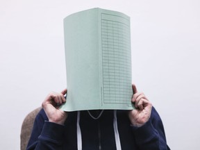 The defendant in the Wermelskirchen abuse complex holds a folder in front of his face in the courtroom in Cologne, Germany, Tuesday, Dec.6, 2022.