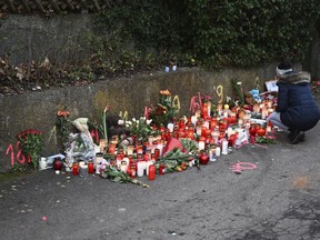 A woman lights a candle at the scene of a knife attack in Illerkirchberg, Tuesday, Dec.6, 2022.