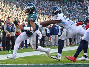 Philadelphia Eagles quarterback Jalen Hurts (1) scores a touchdown against Tennessee Titans linebacker Monty Rice on Sunday.