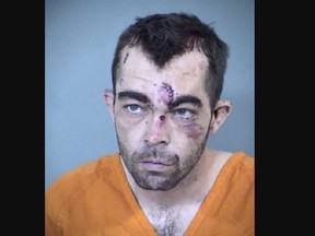Mugshot of man wearing orange shirt with lacerations on face.