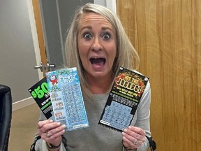Woman holding three scratch-off lottery tickets.