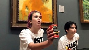 Just Stop Oil protesters glued their hands to a wall after throwing creamed tomato soup at a Vincent van Gogh painting, ‘Sunflowers, at the National Gallery in London, England, Oct. 14, 2022. JUST STOP OIL HANDOUT