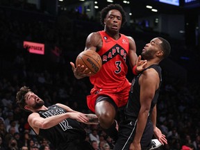 Toronto Raptors forward O.G. Anunoby (3) draws a charge on Brooklyn Nets forward Joe Harris (12) and forward T.J. Warren (1) Friday at Barclays Center.