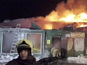 Firefighters work to extinguish a fire in an unregistered home for the elderly in the Siberian city of Kemerovo, Russia, on Dec. 24, 2022.