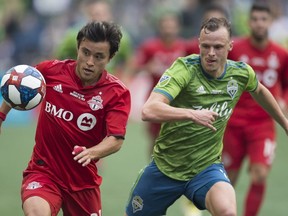 Toronto FC forward Tsubasa Endoh (31) fights for control of the ball with Seattle Sounders defender Brad Smith (11) during the first half of MLS Cup final soccer action in Seattle on Sunday, November, 10, 2019.&ampnbsp;Endoh is underging treatment in his native Japan for acute leukemia.