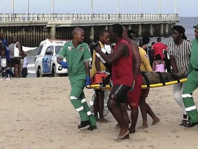 Paramedics carry a person on a stretcher on the Bay of Plenty Beach in Durban, South Africa, Saturday, Dec. 17, 2022.