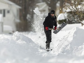 A man shovels a path to his house in Fort Erie, Ont., Saturday, Nov. 19, 2022.