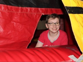 Zach Rayment peers from a bouncy castle at the Variety Village Christmas Party.
