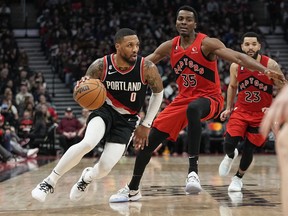 Portland Trail Blazers guard Damian Lillard moves to the net past Toronto Raptors forward Christian Koloko.