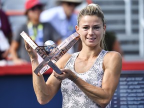 Camila Giorgi of Italy poses with the winners trophy after defeating Karolina Pliskova of the Czech Republic during her Women's Singles Final match on Day Seven of the National Bank Open presented by Rogers at IGA Stadium on August 15, 2021 in Montreal.