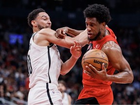 Ben Simmons of the Brooklyn Nets and Thaddeus Young of the Toronto Raptors battle or the ball during the second half of their NBA game at Scotiabank Arena on November 23, 2022 in Toronto, Canada.