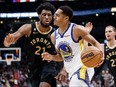 Jordan Poole of the Golden State Warriors drives to the net against Thaddeus Young of the Toronto Raptors during the first half of their NBA game at Scotiabank Arena on December 18, 2022 in Toronto, Canada. Photo by Cole Burston/Getty Images