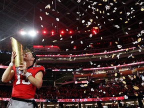 Stetson Bennett #13 of the Georgia Bulldogs celebrates with the College Football Playoff National Championship Trophy after defeating the TCU Horned Frogs in the College Football Playoff National Championship game at SoFi Stadium on January 9, 2023 in Inglewood, California. Georgia defeated TCU 65-7.