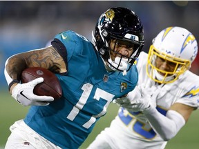 Evan Engram of the Jacksonville Jaguars carries the ball against the Los Angeles Chargers during the second half of the game in the AFC Wild Card playoff game at TIAA Bank Field on January 14, 2023 in Jacksonville, Florida.