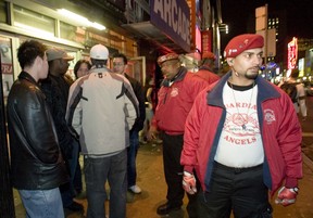 Members of the Guardian Angels talk to passersby as they walk up Yonge St. in the area of the Boxing Day shooting.