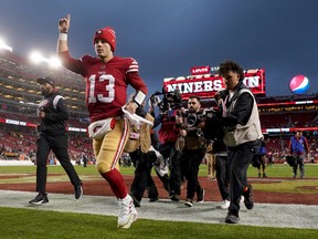 San Francisco 49ers quarterback Brock Purdy gestures as he runs off the field after defeating the Seattle Seahawks.