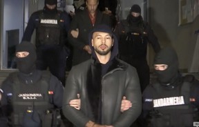 In this grab taken from video released by Observator Antena 1, Social Media personality Andrew Tate is led away by police, in the Ilfov area, north of Bucharest, Romania, Thursday, Dec. 29, 2022. (Observator Antena 1 via AP)