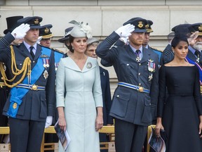 From front left, Prince William, Kate the Duchess of Cambridge, Prince Harry and Meghan the Duchess of Sussex, with various other dignitaries and guests, before watching a flypast of Royal Air Force aircraft over Buckingham Palace in London, Tuesday, July 10, 2018.